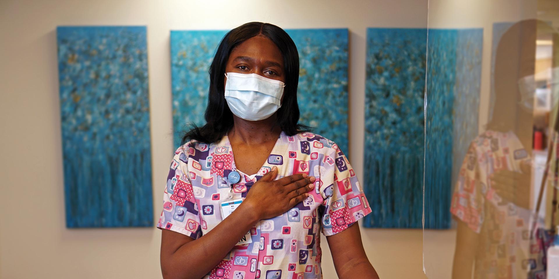 Sheryl Grant stands in her unit with her hand over her heart