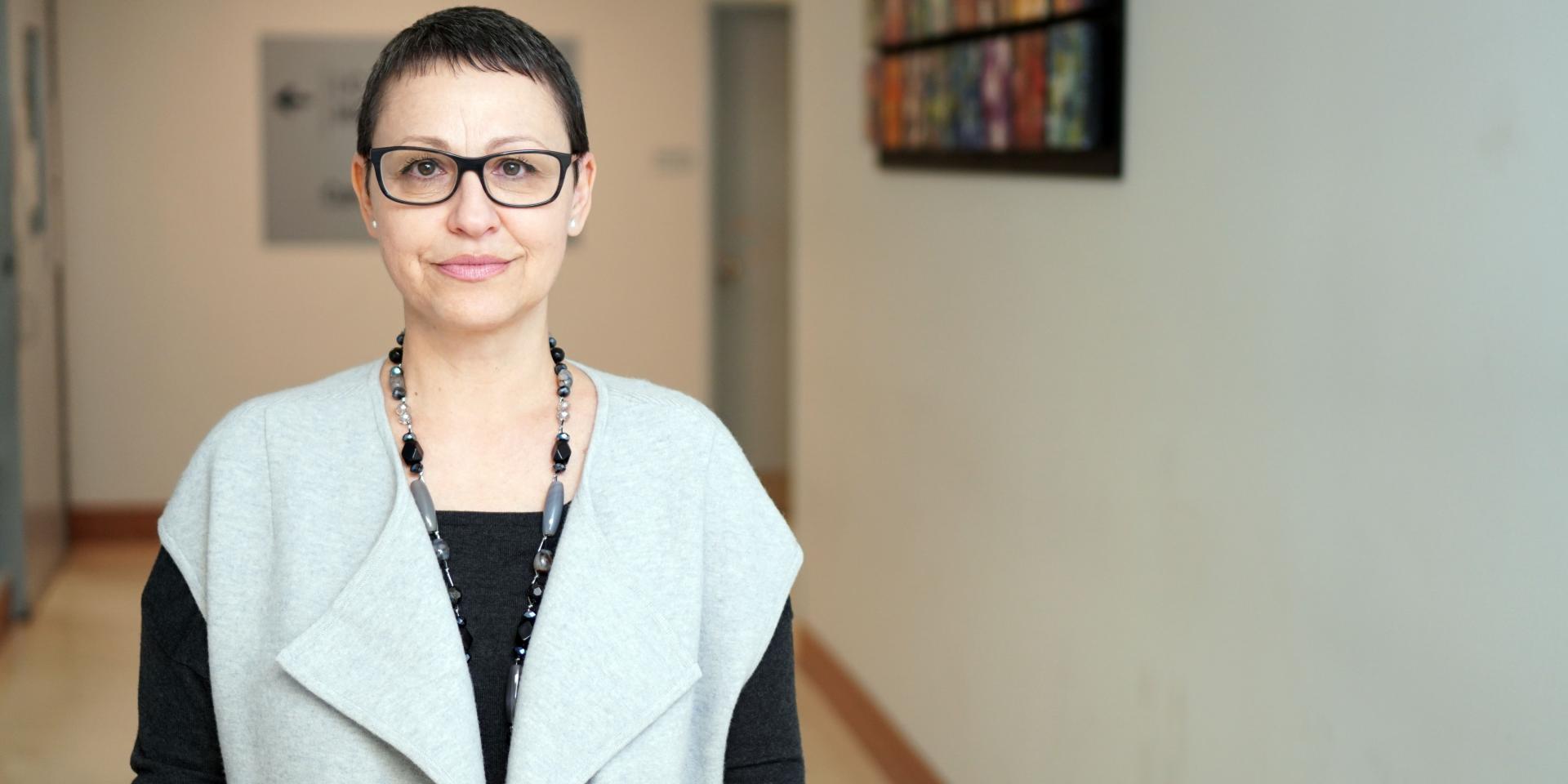 Social worker Alina Mustata stands in the middle of a hospital hallway.