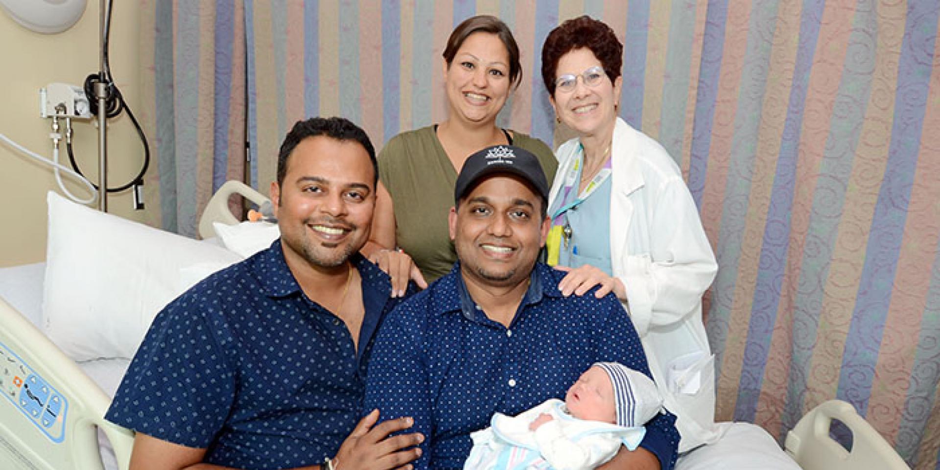 New parents Asish Purushan and Krishneel Lall with baby Sidharth, surrogate Mazyline McCarthy and obstetrician and gynecologist Dr. Brenda Woods