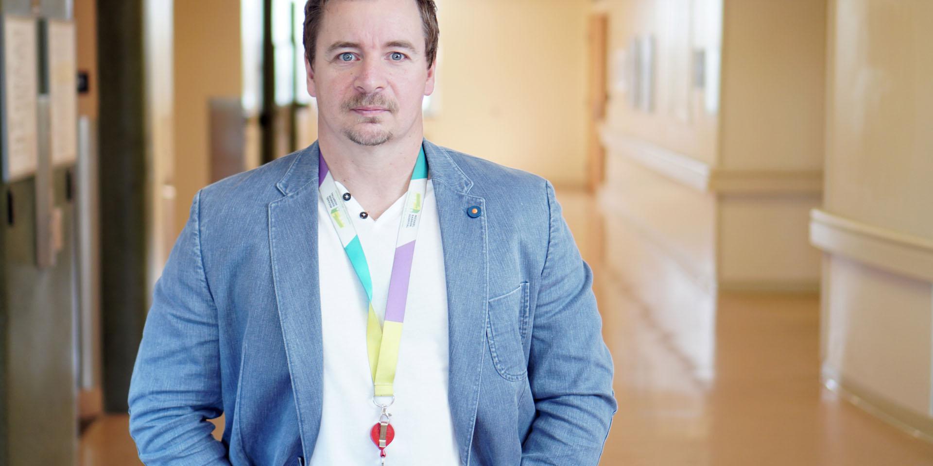 Sean Healey, Social Worker at Michael Garron hospital, standing in hallway