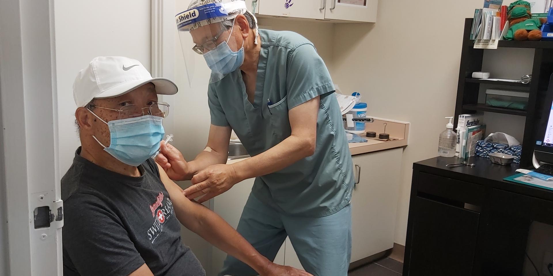 Foo Ngan, an 82-year-old East Chinatown resident, receives his second dose of the COVID-19 vaccine at the office of his family doctor, Dr. Terence Leung.