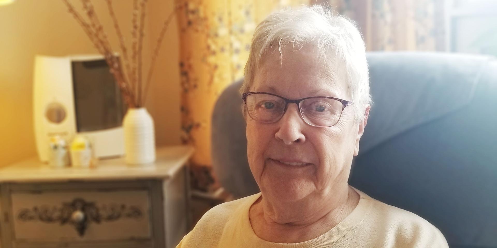 Long-term care home resident sitting in chair smiling