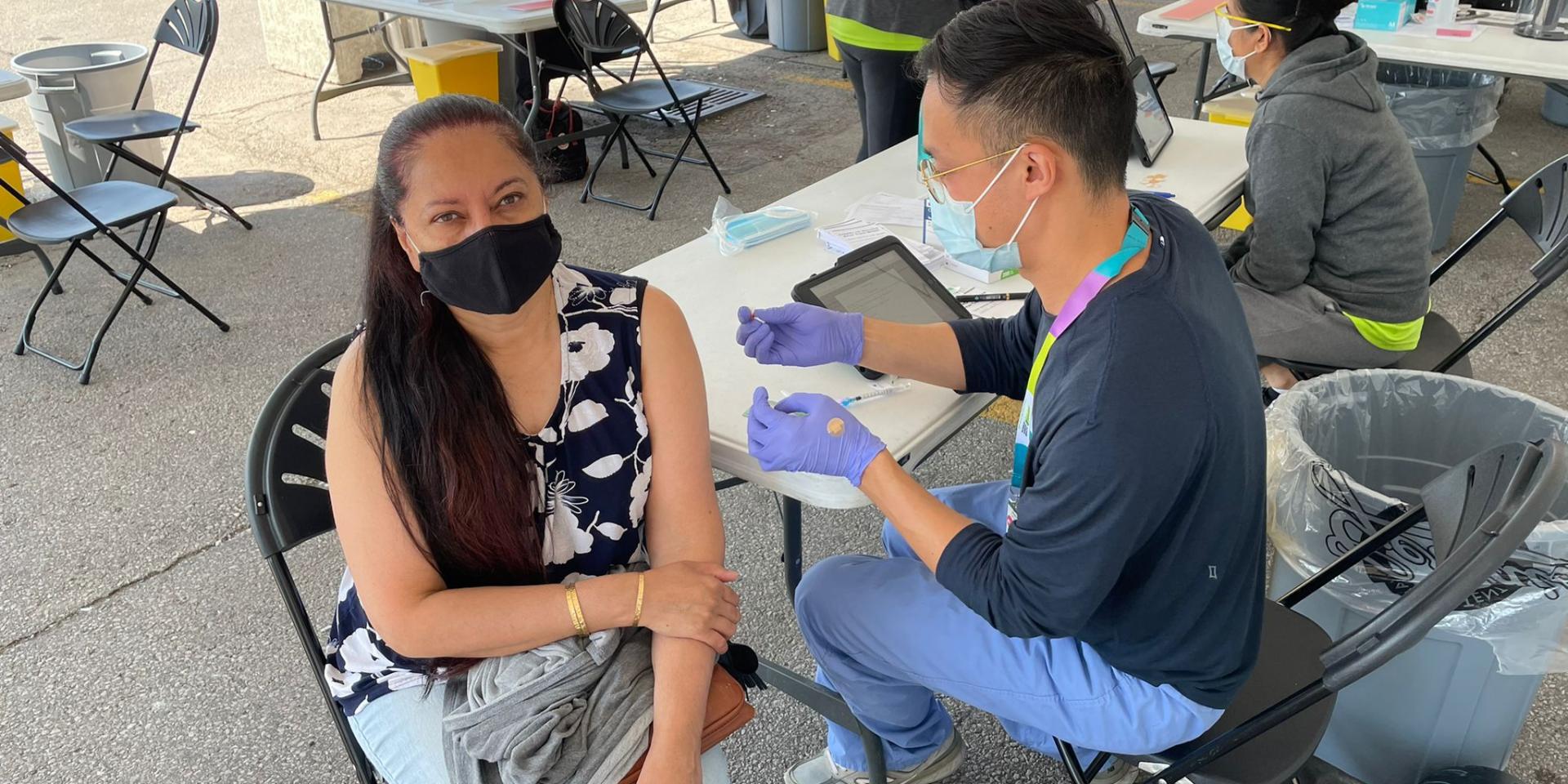 A woman gets vaccinated against COVID-19 at a clinic in Shoppers World Danforth.