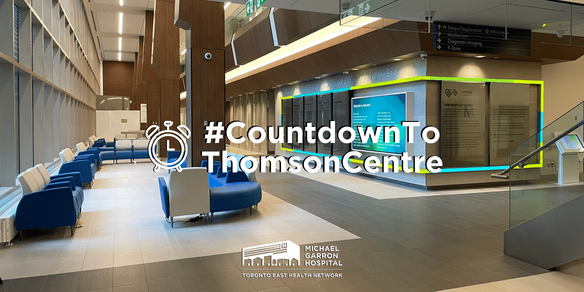 Wide shot of the main lobby in the new Thomson Centre with overlay text that reads "#CountdowntoThomsonCentre" with an alarm emote on the left. MGH logo is underneath it