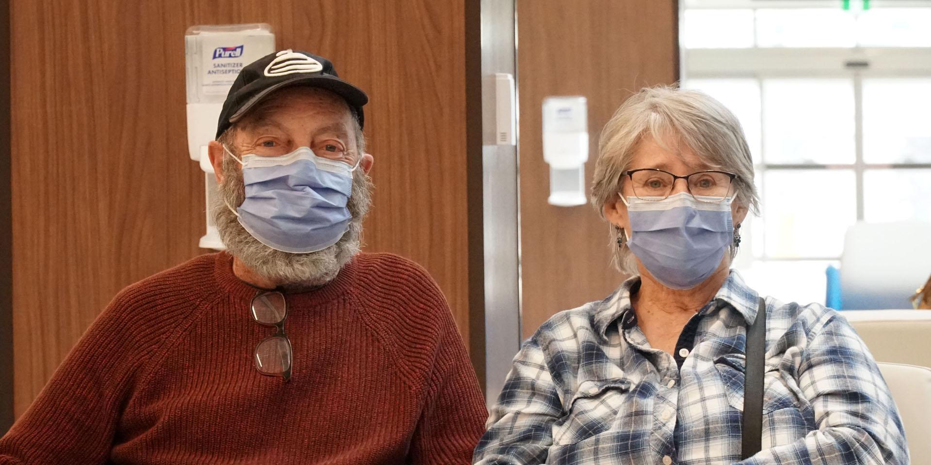 Two patients sitting in Thomson Centre lobby wearing masks