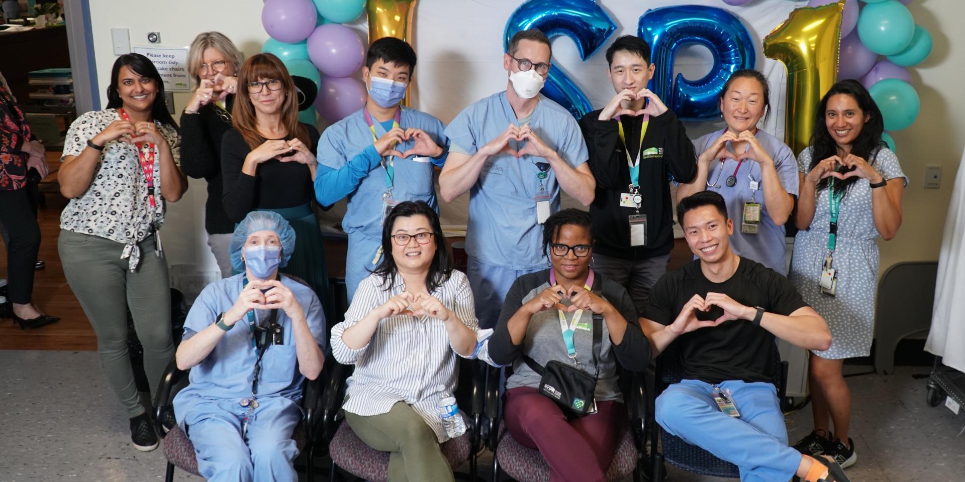 Members of MGH’s Long Stay Critical Care Care Team make hearts with their hands.