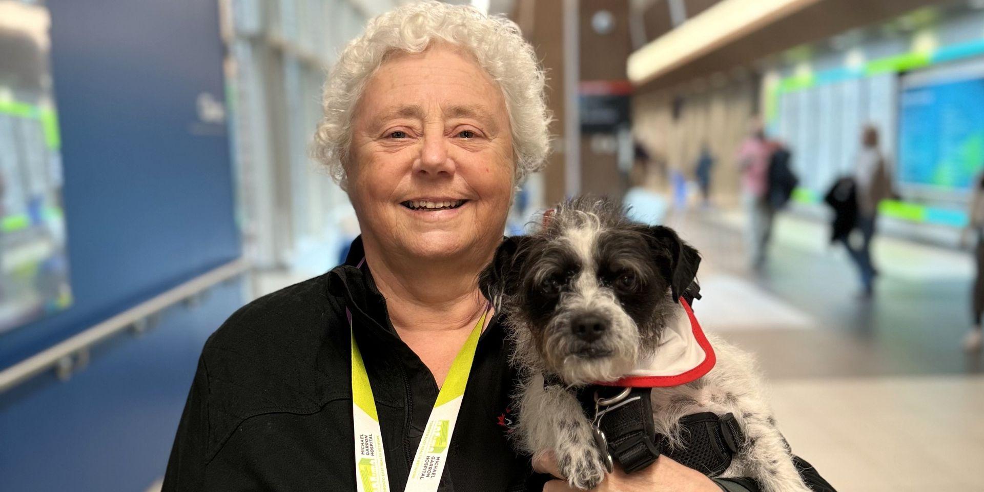 Christine MacLean holding Tilley smiling in the Thomson Centre Lobby.