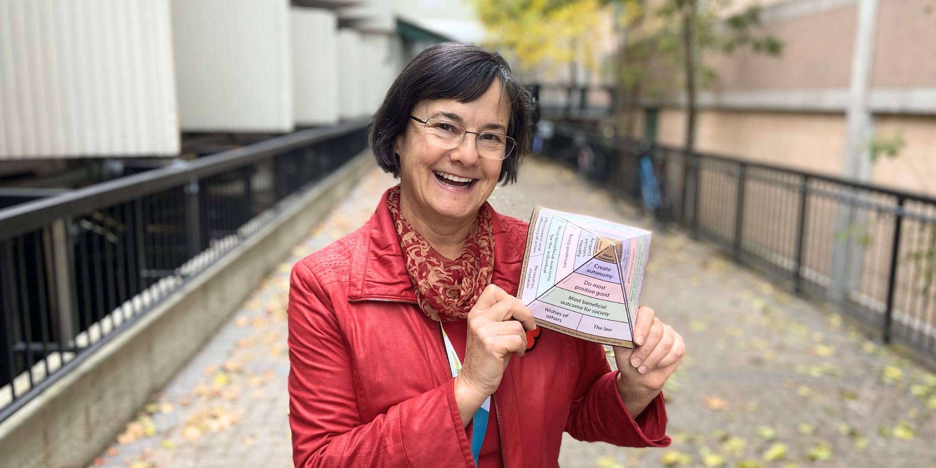 Maria McDonald, Bioethicist at Michael Garron Hospital, stands outside holding an ethical grid.