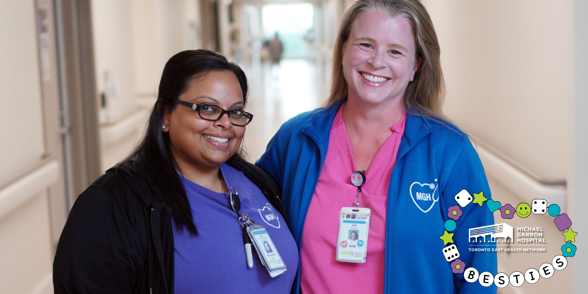 Two nurses smiling and standing in a hallway at Michael Garron Hospital.