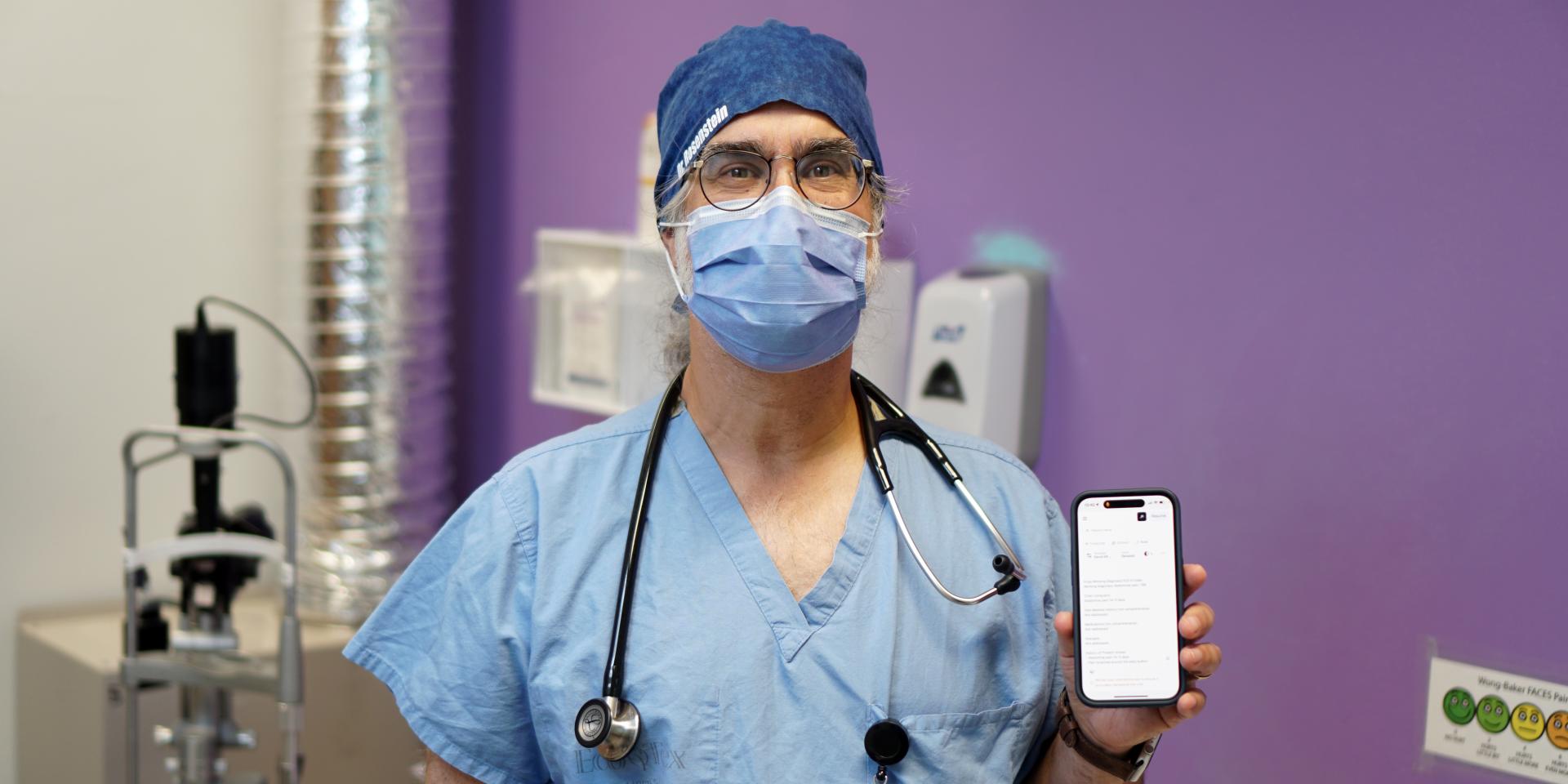 Dr. David Rosenstein, Emergency Physician and Information Technology Lead in MGH’s ED, holds a smartphone displaying the Ambient Scribe tool.