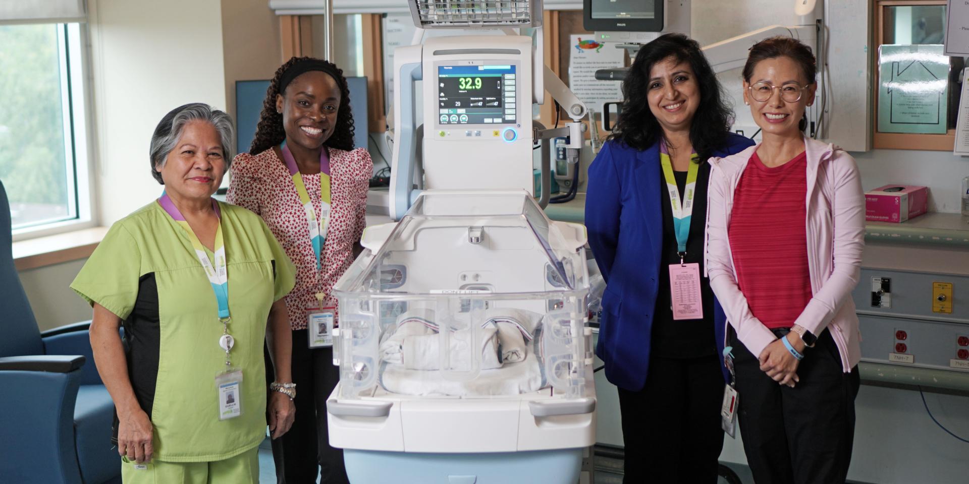 People stand and smile around the new incubator