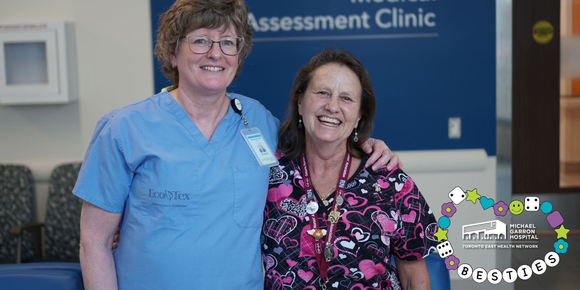 Two nurses smiling and standing next to each other. One nurse has her arm around the other.