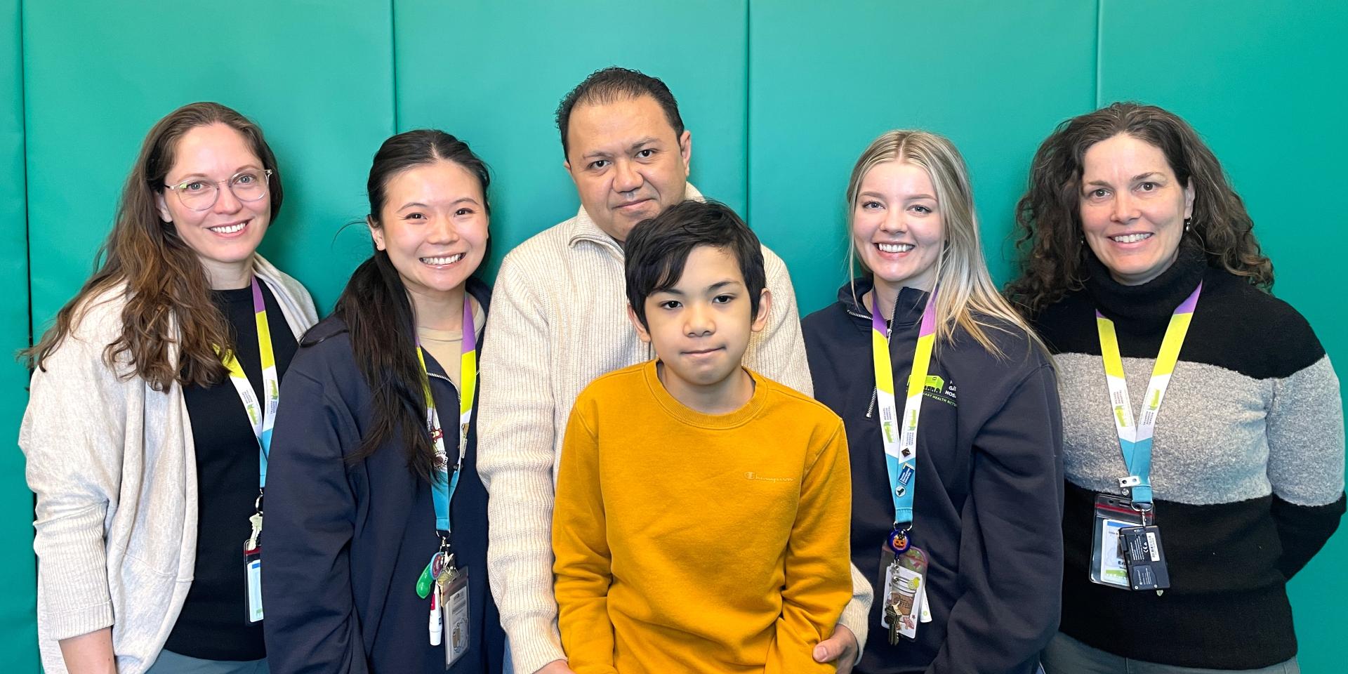 Sebastian and his dad pose with staff from Michael Garron Hospital's Extensive Needs Service.