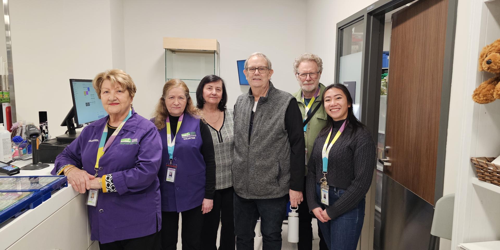 Staff and volunteers stand together inside The General Store’s new location inside the hospital.