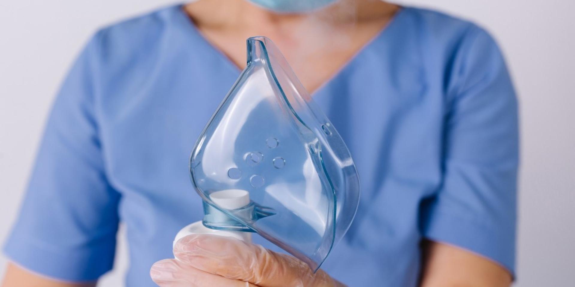 Healthcare worker holds a mask in their hands