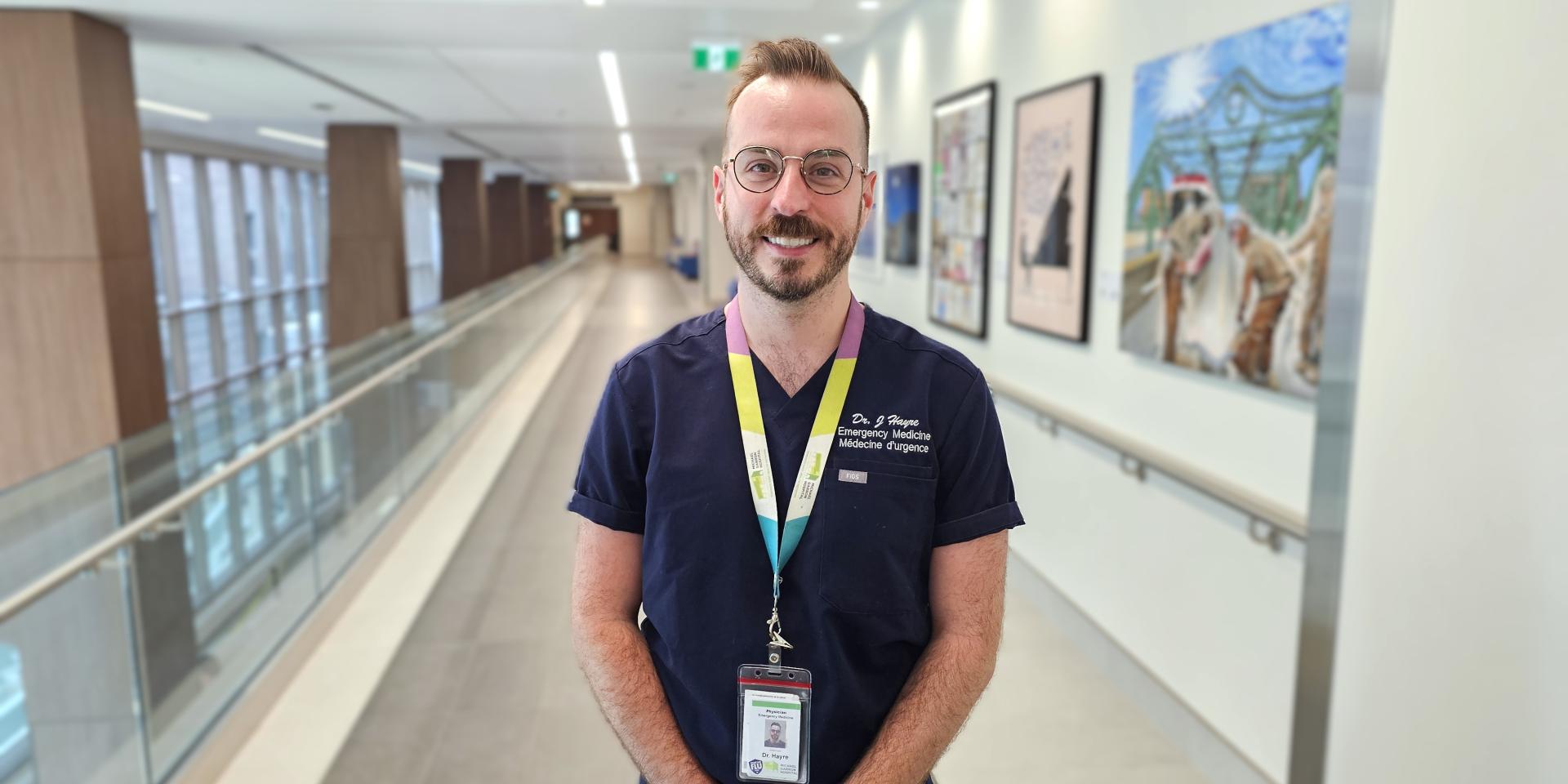 A physician stands in a hospital hallway.