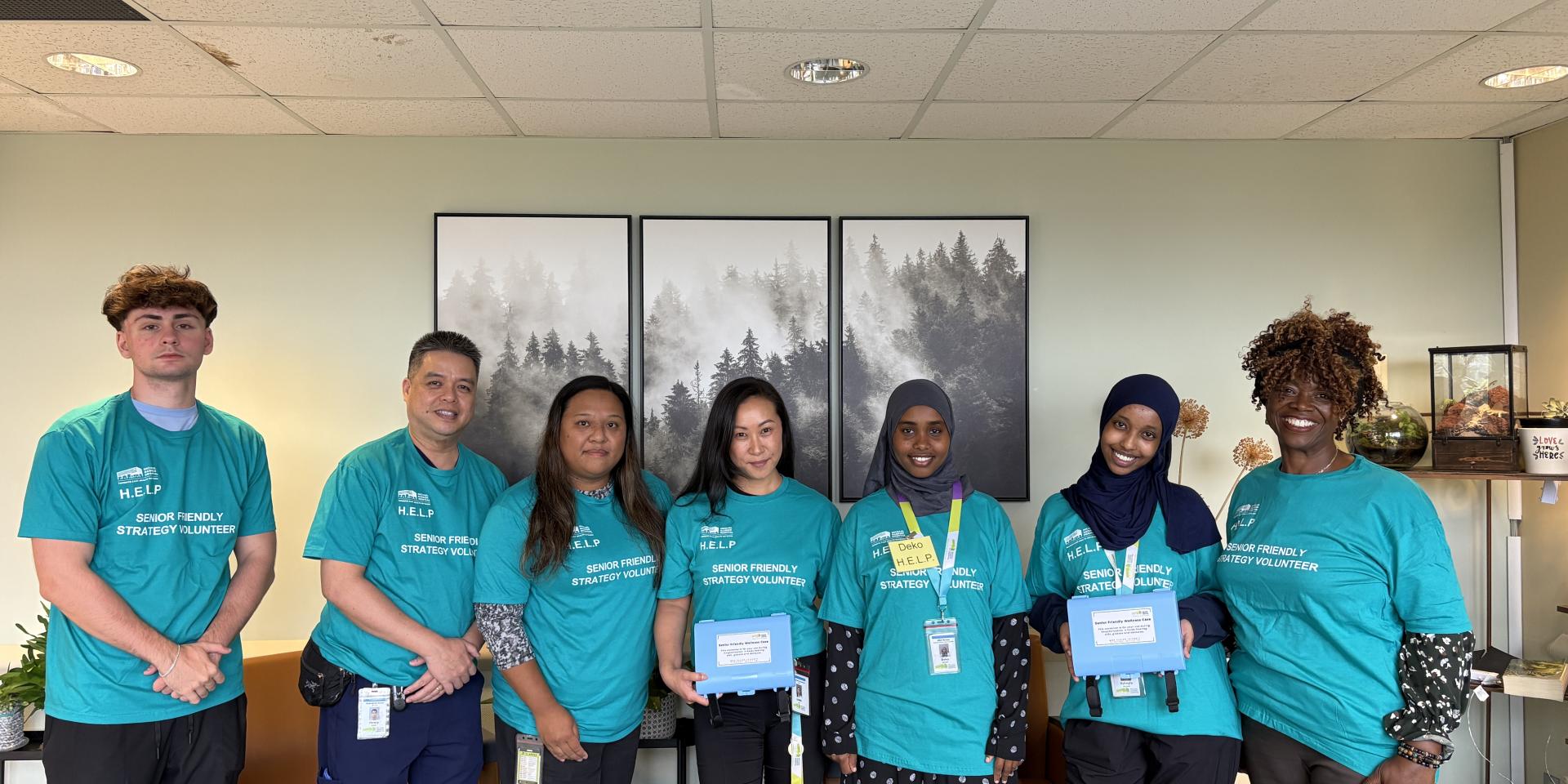 A group of volunteers in a hospital stand together while smiling at the camera 