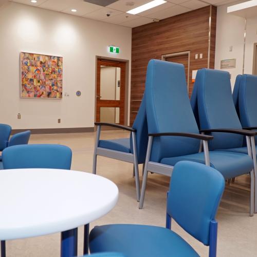 Waiting room with large chairs for adults and small chairs and tables for children.