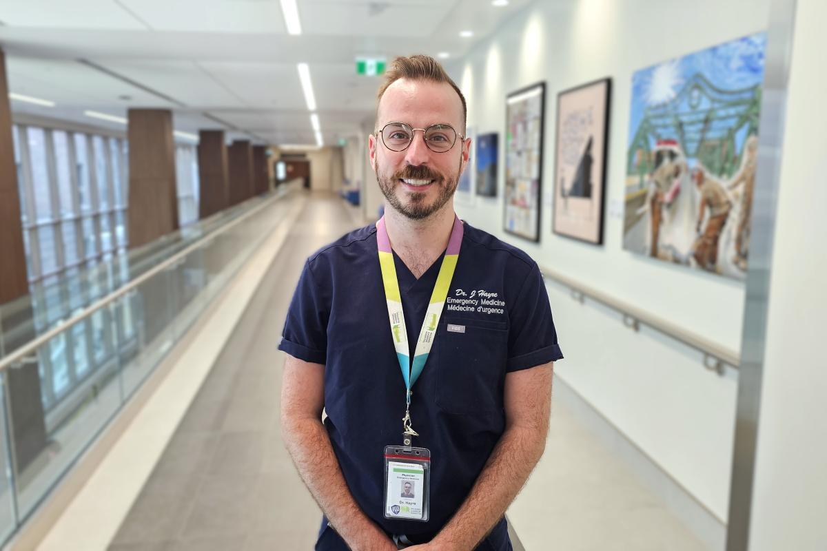 A physician stands in a hospital hallway.