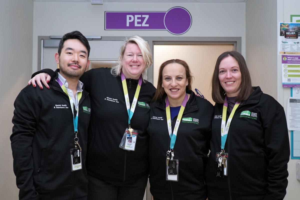 Four MGH staff members pose in front of a sign that says "PEZ".