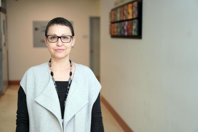 Social worker Alina Mustata stands in the middle of a hospital hallway.