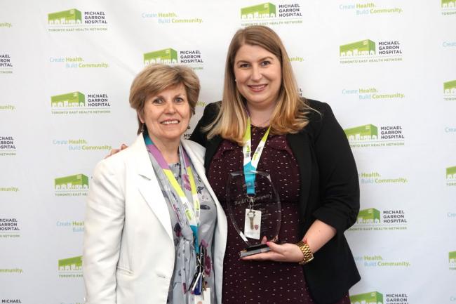 Leah Dunbar, a project manager for the Mobile Crisis Intervention Team, accepted the Build Community award for her first ever poster project. She credits her success to her director Linda Young (left) (Photo by: Ellen Samek)