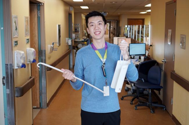 Occupational therapist Jonathan Chiu displays sock aid and long handle shoe horn.