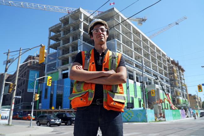 Gabriele Mabrucco standing with his arms crossed in front of MGH's Patient Care Centre