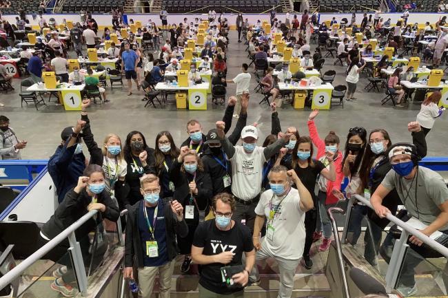 Members MGH's vaccine team at Scotiabank Arena raising hands in celebration.