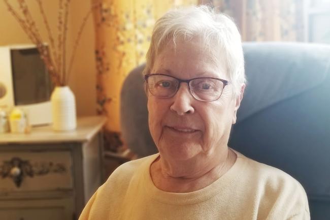 Long-term care home resident sitting in chair smiling