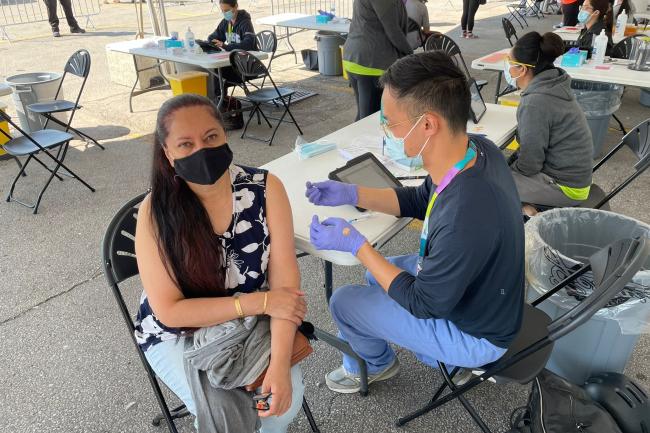 A woman gets vaccinated against COVID-19 at a clinic in Shoppers World Danforth.