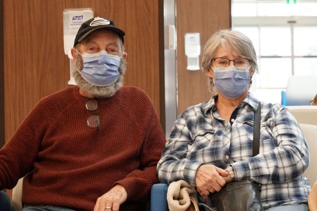 Two patients sitting in Thomson Centre lobby wearing masks