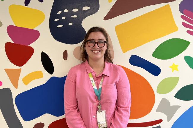 Siobhan Pickering standing in front of a colourful wall at MGH