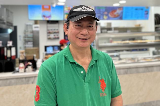 Jack Chen smiling in front of JK Pizza. 