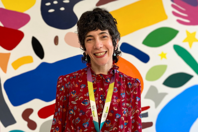 Julia King, Registered Dietitian at Michael Garron Hospital, stands in front of a colourful mural.