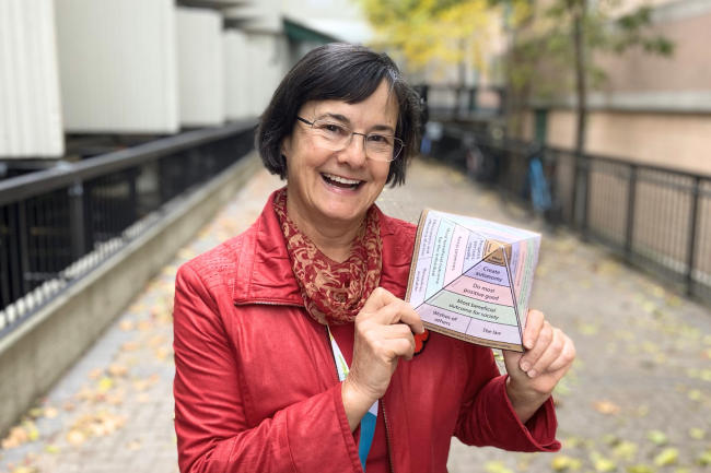 Maria McDonald, Bioethicist at Michael Garron Hospital, stands outside holding an ethical grid.