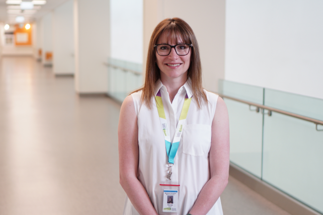 Sarah Wright, Research Scientist, stands in hospital hallway. 