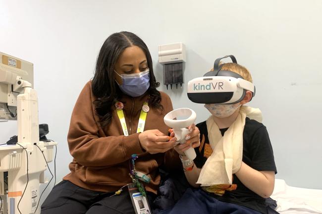 A Child Life Specialist helps a paediatric patient with a virtual reality activity.