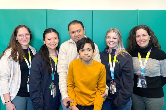 Sebastian and his dad pose with staff from Michael Garron Hospital's Extensive Needs Service.