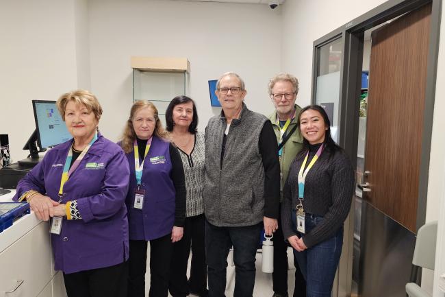 Staff and volunteers stand together inside The General Store’s new location inside the hospital.