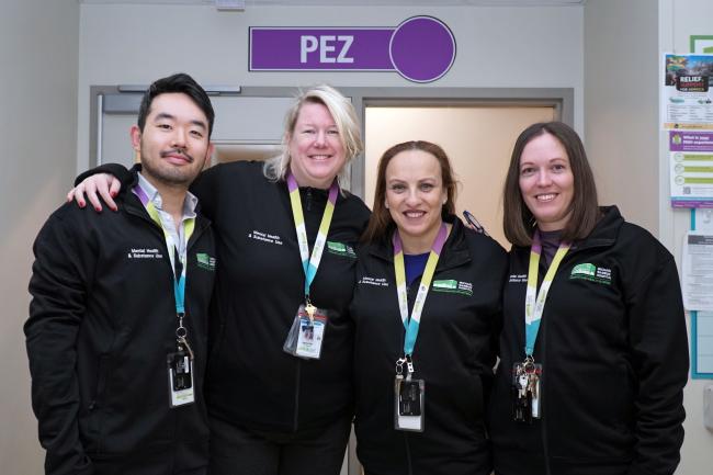 Four MGH staff members pose in front of a sign that says "PEZ".