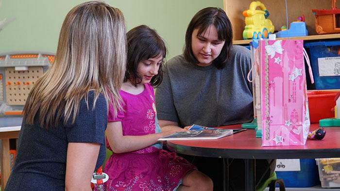 Chelsea, with her mother Shauna and Diana Tustin in the G7 playroom. 