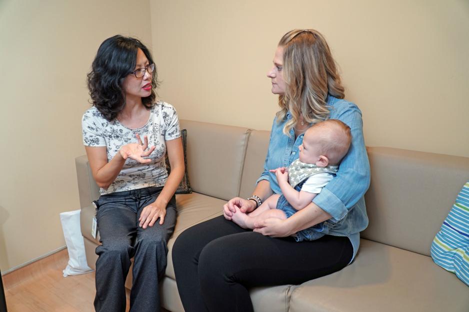 Sung-Ju Hong, Georgia Tsialtas and baby Christopher MGH lactation consultant speaking with new parent, Georgia