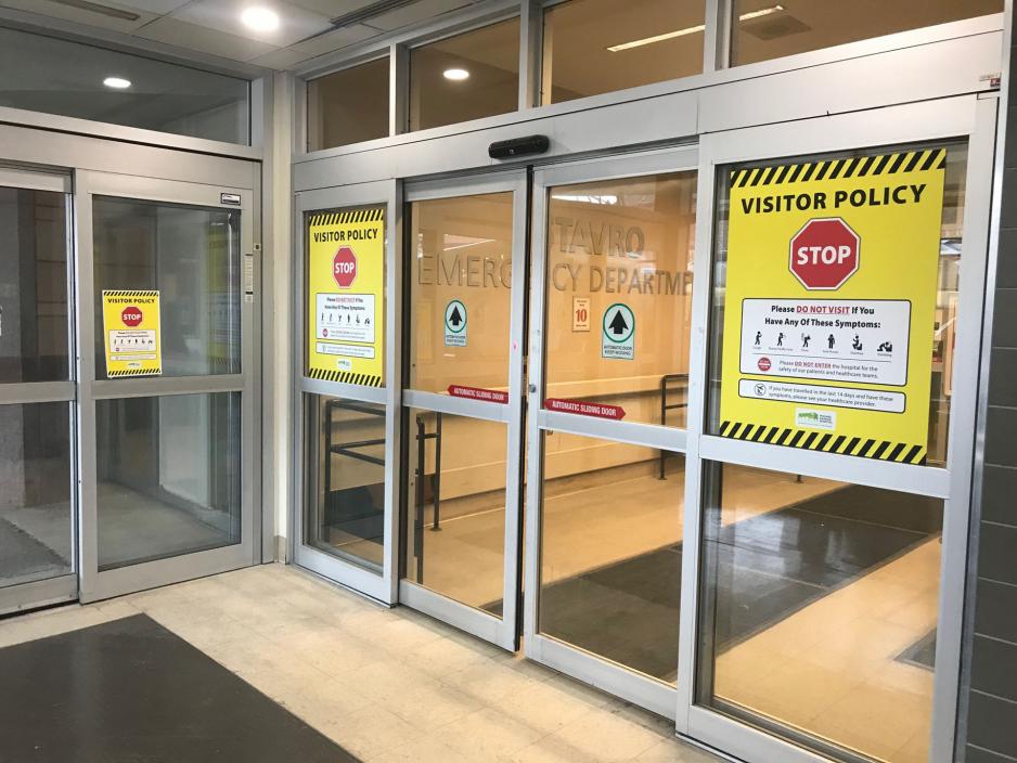 Image of signage at MGH's ED entrance instructing visitors not to visit if they are feeling ill