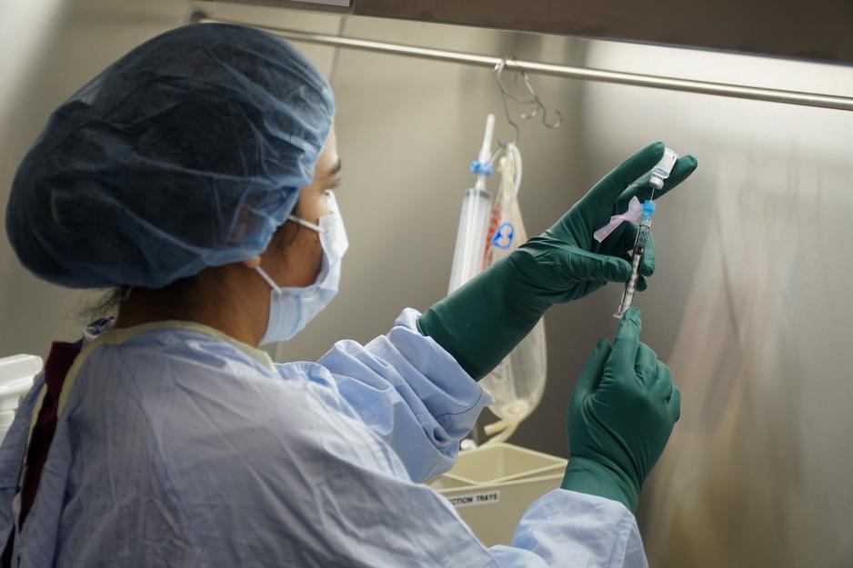 A member of MGH's Pharmacy team prepares the COVID-19 vaccine for administration.