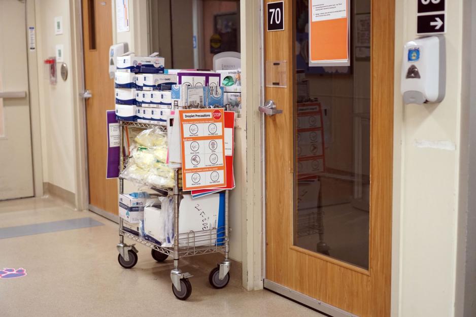 A cart stocked with PPE sits outside a negative pressure room in the Emergency Department.