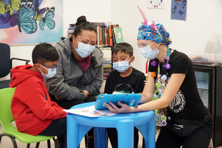 Morgan Livingstone, Child Life Specialist at MGH, works with a family in the Child and Youth Emergency Zone.