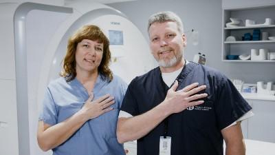 Cynthia and Tom Hocking, each standing with a hand over their heart.