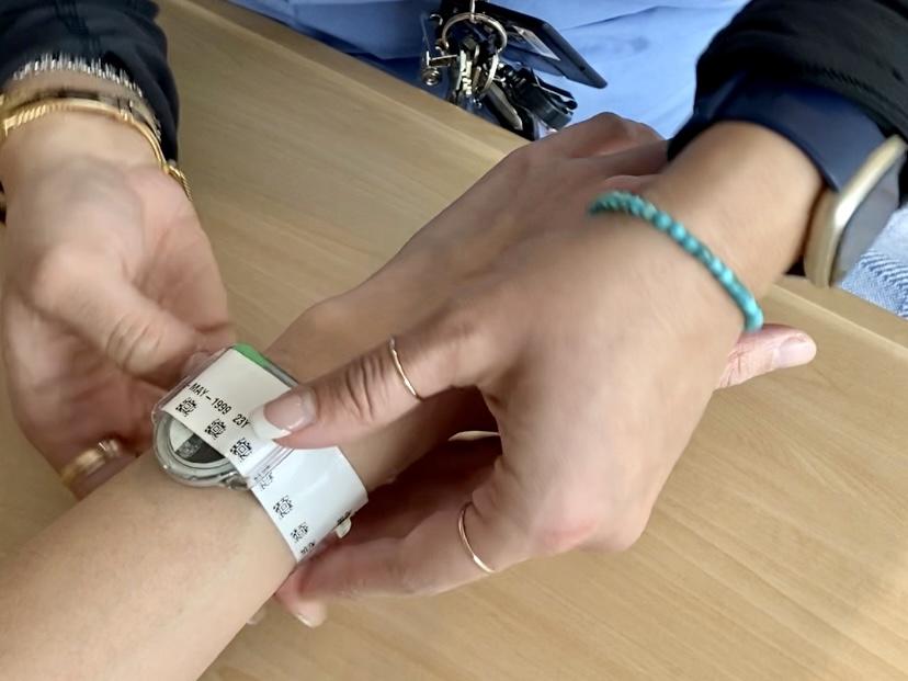 A nurse attaches a bracelet to a patient