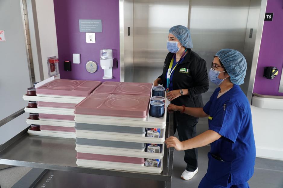 Melanie and Elaine delivering food trays